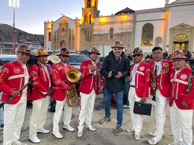 Mario Trotamundos con-varios-músicos-de-la-banda-Intercontinental-Poopó-delante-del-Santuario-del-Socavón-de-Oruro Bolivia